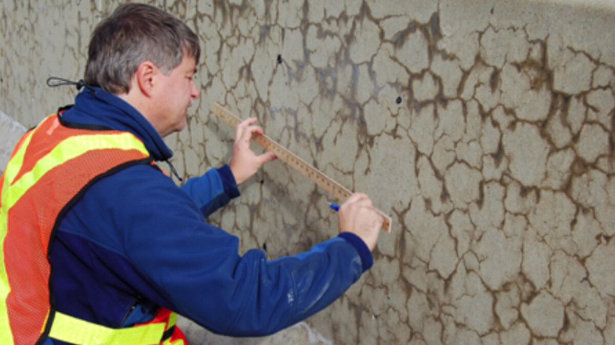 A worker measures cracks in a concrete median affected by alkali-silica reaction. A team led by UNL's Jinying Zhu has earned a federal grant to develop an online system to monitor and evaluate the health of concrete structures, including nuclear power plants.