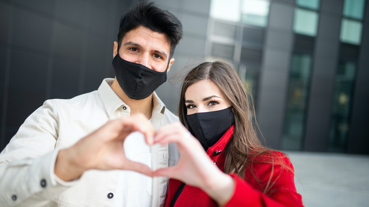 Couple making a heart shape with their hands.