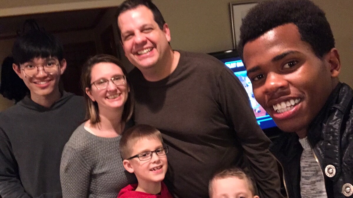 Lindsay Augustyn, assistant director and communications coordinator for the Center for Science, Mathematics and Computer Education, poses with her family and their two host students, Hang "Voyage" Yuan (left) and Thierry Bienvenu.