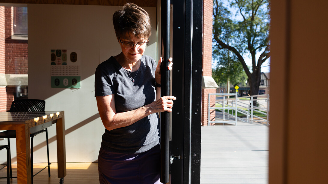 Jean Stryker opens the large sliding door at the front of the Art Chapel closed. Designed by Nebraska architecture students, the door contains a smaller, Craftsman-style door that can be used in cold or inclement weather. It is designed to open the Art Chapel up and draw members of the public into the space.
