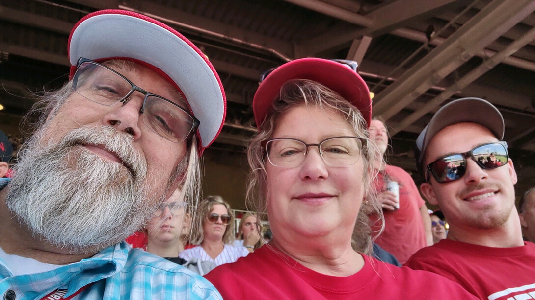 Mike Case (from left), his wife, Laurie, and son, Matthew, at a Husker football game in Memorial Stadium.