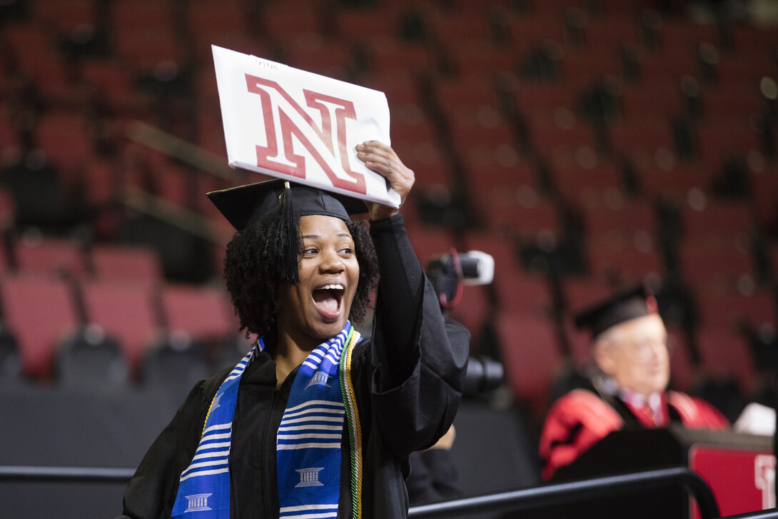 Cierra Tooley gestures to her cheering section of more than 30 family and friends as she celebrates her bachelor of science in forensic science degree during the undergraduate commencement ceremony Dec. 19 at Pinnacle Bank Arena. Tooley said she is the first university graduate in her family.