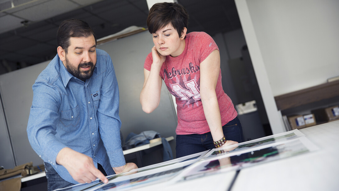 Walker Pickering (left) discusses print quality with his UCARE student Shalbey Workman. Pickering is a photography professor who has created a series of behind-the-scenes photos of marching bands and drum corps from high school to college.