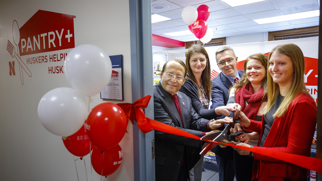 Juan Franco (left) helps celebrate the opening of Nebraska's food pantry for students with Chancellor Ronnie Green (third from left) and others.