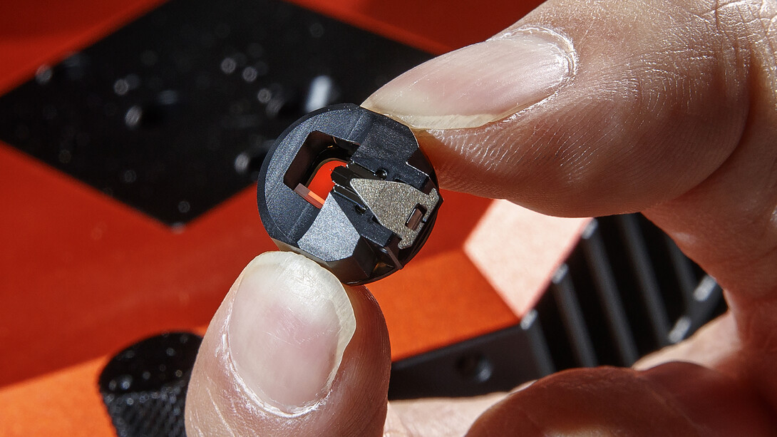 Yang holds a piece of the atomic force microscope used to measure the beetle's surface. A small wire can barely be seen in the middle of the piece. Unseen is a two-nano-size probe attached to the wire, which does the actual measuring.