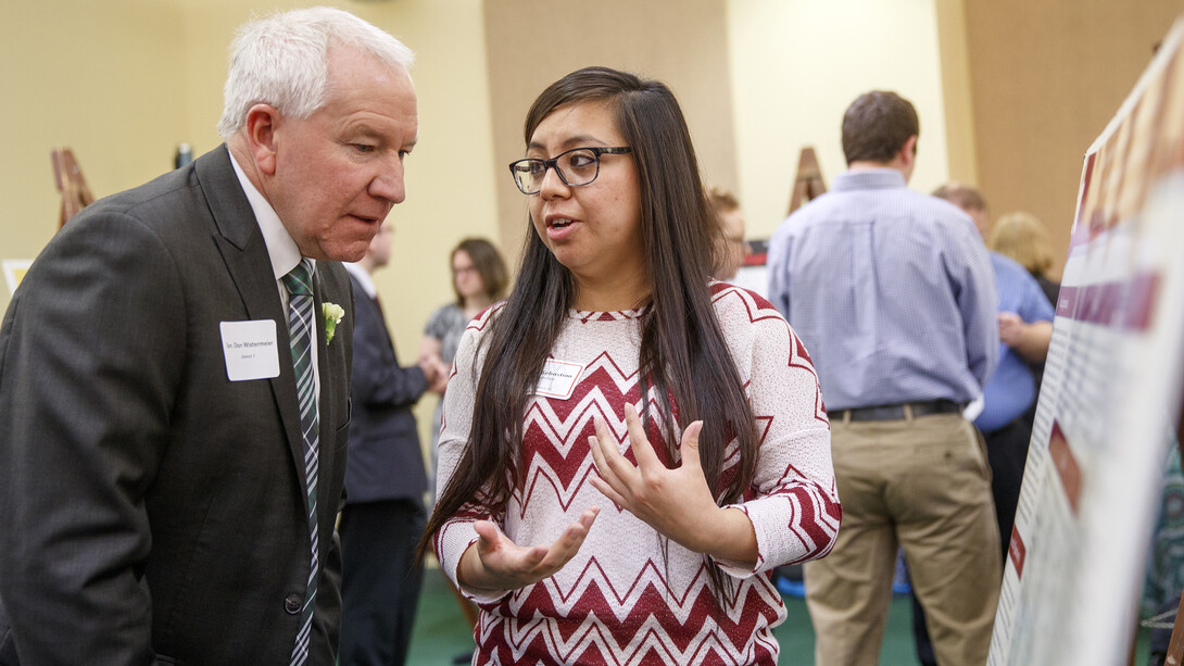 Reiza Izabel Sebastian (right) explains her research in language development of Spanish- and English-speaking preschoolers to Nebraska Sen. Dan Watermeier. State legislators are invited to participate in research poster session at Nebraska State Capitol as part of the university's spring research fair.