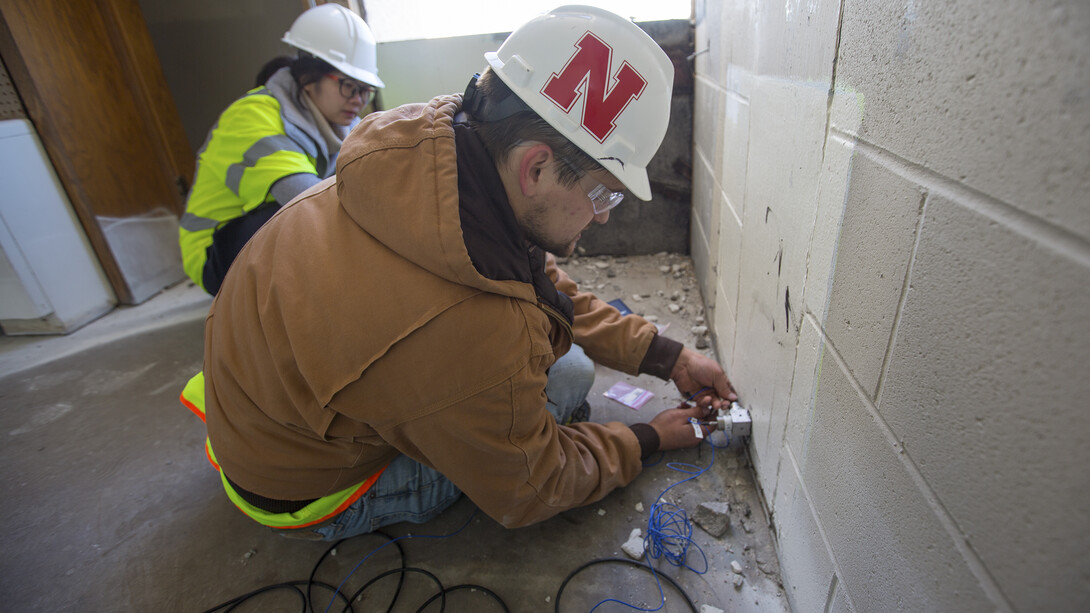 Garrett Martindale (right) and Yijun Liao, graduate students in Richard Wood's lab, install an accelerometer on the eighth floor of Pound Hall on Dec. 2. Data collected by the team is being used to refine engineering models and improve the resilience of buildings.