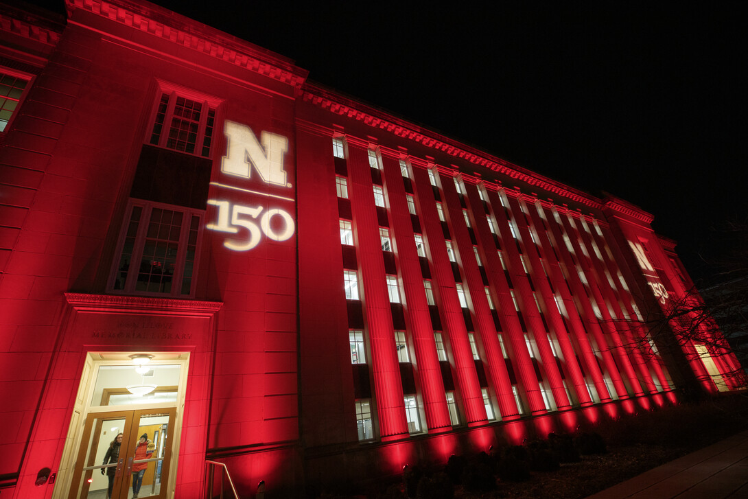 The architecture of Nebraska's Love Library is highlighted by red light and the N150 logo for Glow Big Red.