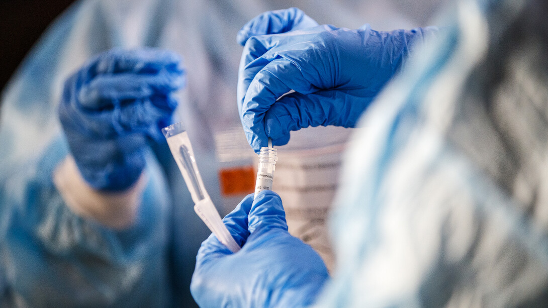 Medical workers remove a swab for a COVID-19 screening at the TestNebraska site at the University of Nebraska–Lincoln. The university providing daily updates on numbers of tests and positive cases in its COVID-19 dashboard.