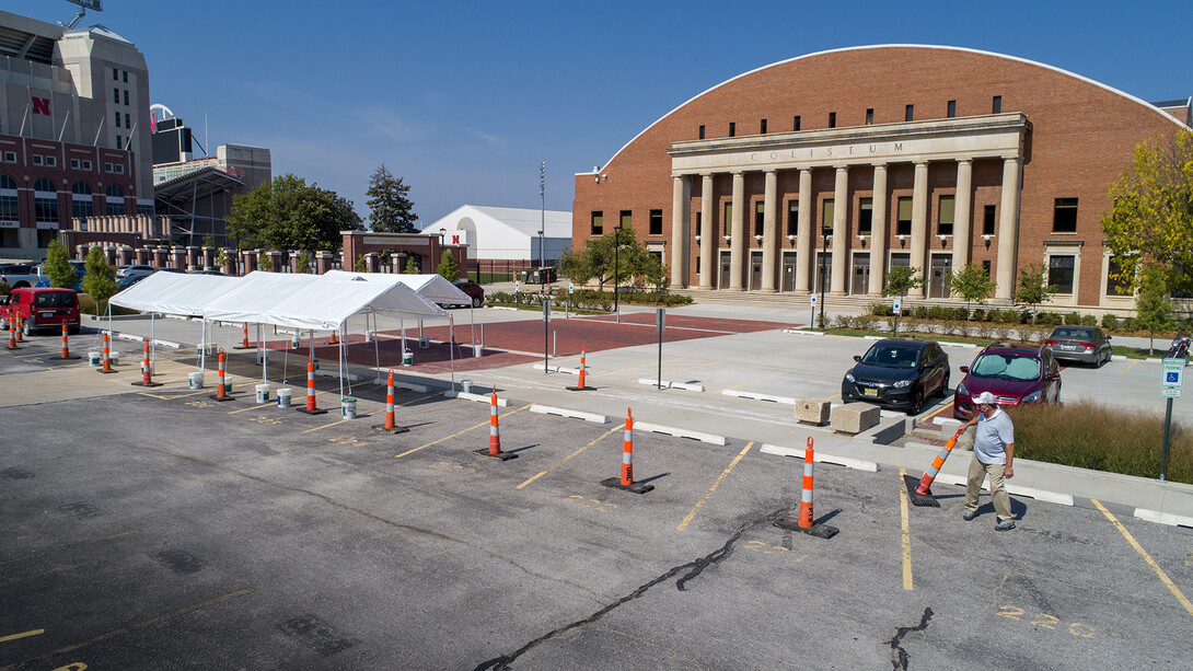 Jeff Culbertson, assistant director of operations for Landscape Services, places a traffic cone near the tents being used for randomized testing for COVID-19. The testing site is for students, faculty and staff who receive an email request.