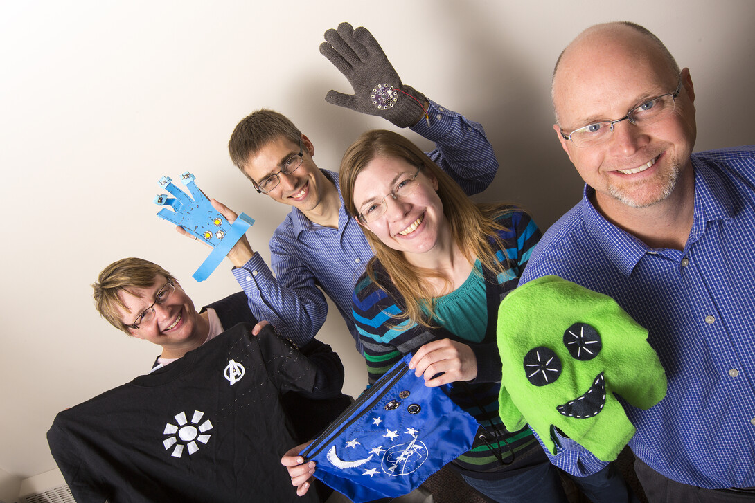 Brad Barker, right, Jennifer Melander, Carl Nelson and Michelle Krehbiel show off examples of wearable tech that are designed by 4-H students using micro-controllers.