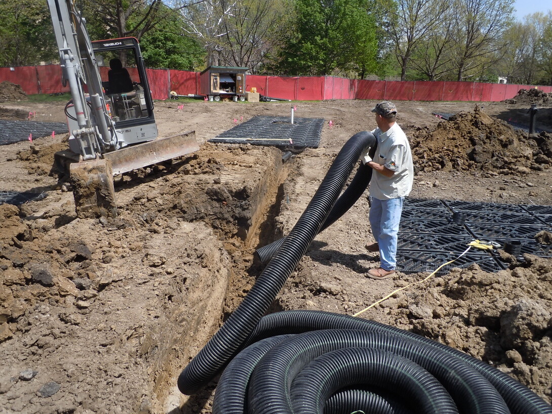 Construction workers with Dreamscapes install the overflow drainpipe that connects the silva cell structures to the storm sewer. The overflow pipe acts only as a precaution in larger rain events or a succession of rain events if the silva cells become saturated.