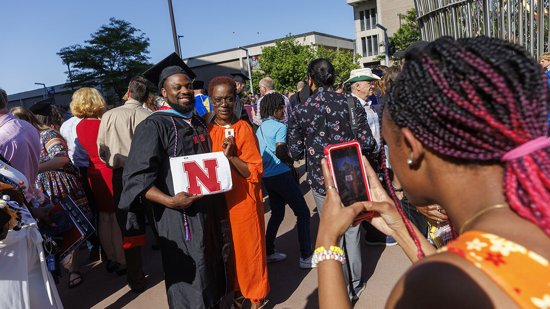 Darwin Archie-Pettis poses for family photos with his newly earned master’s degree outside Pinnacle Bank Arena after the May 13 graduate and professional degree ceremony.