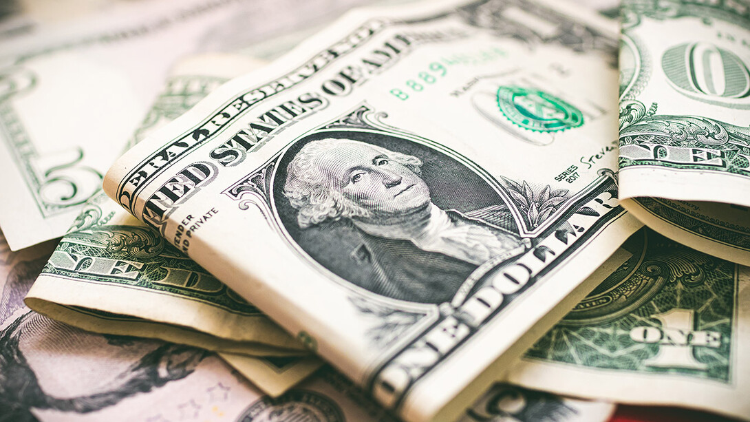 Pile of American currency with one-dollar bill on top