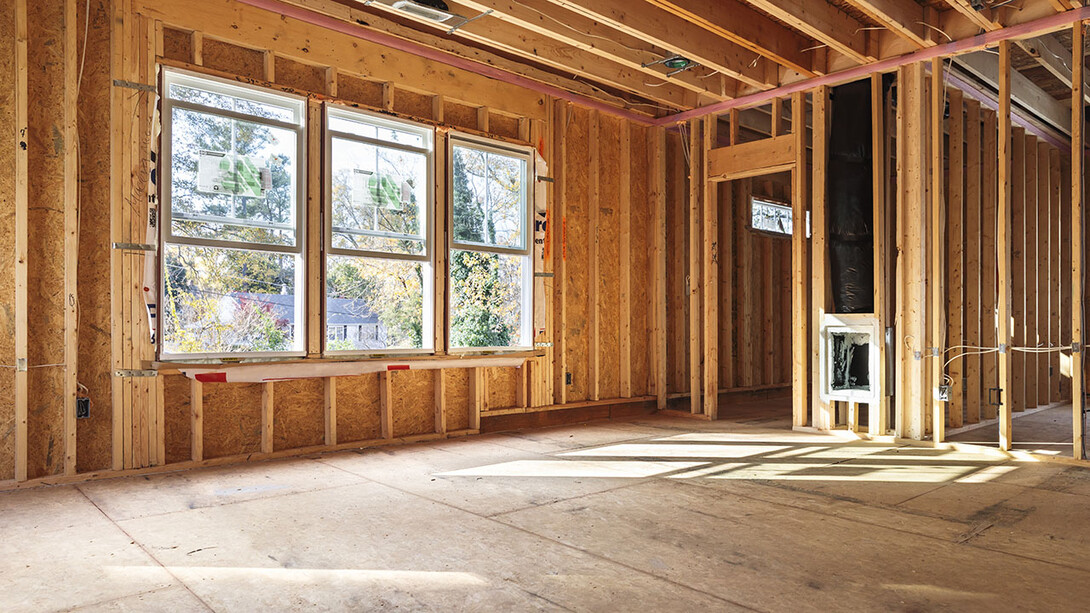 Inside of house being constructed, with frame and exterior walls completed