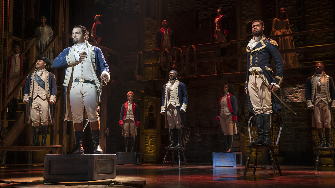 The cast of "Hamilton" performs on stage.