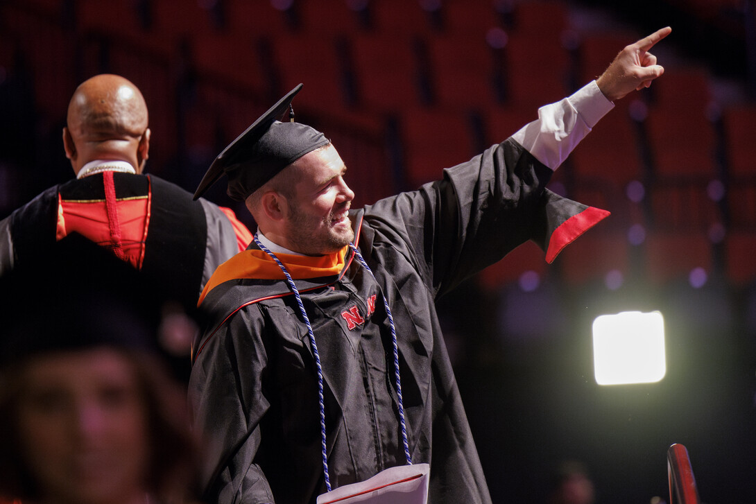 Nolan McCulloch of Tremonton, Utah, points to his family and friends after receiving his Master of Engineering Management.