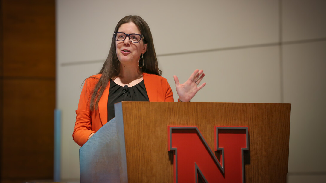 Jessica A. Shoemaker, Steinhart Distinguished Professor of Law, speaks behind a wooden lectern with a red Husker "N" on the front.