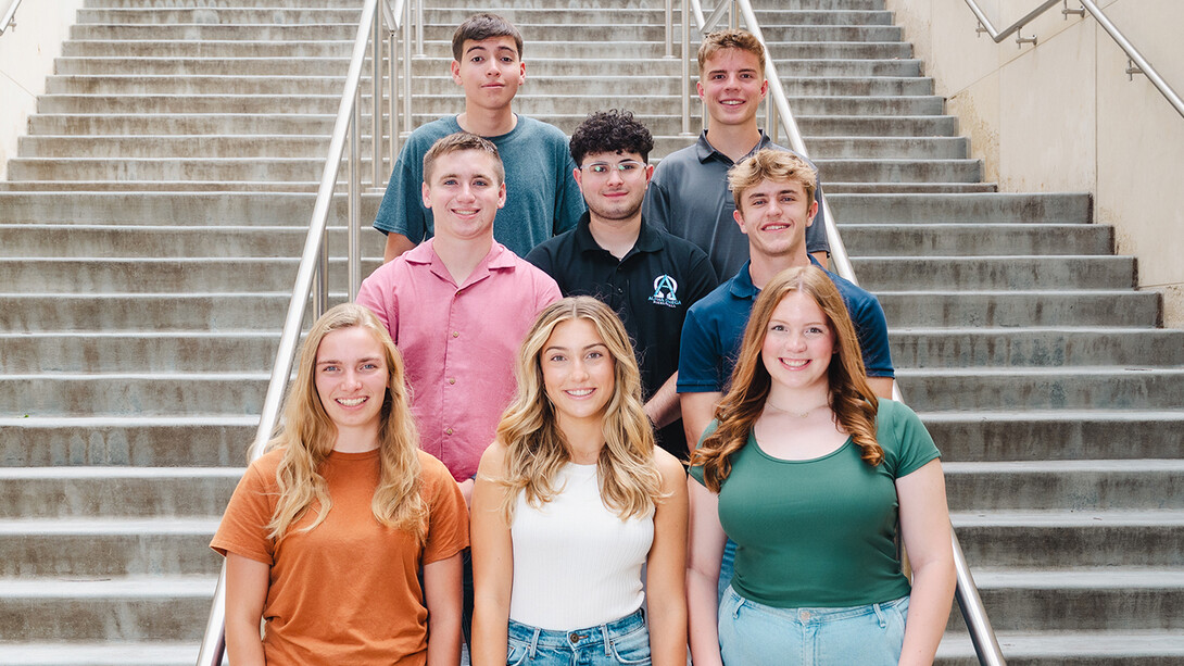 Eight Husker students — all members of the second cohort of Entrepreneurship Catalysts — pose on a staircase.