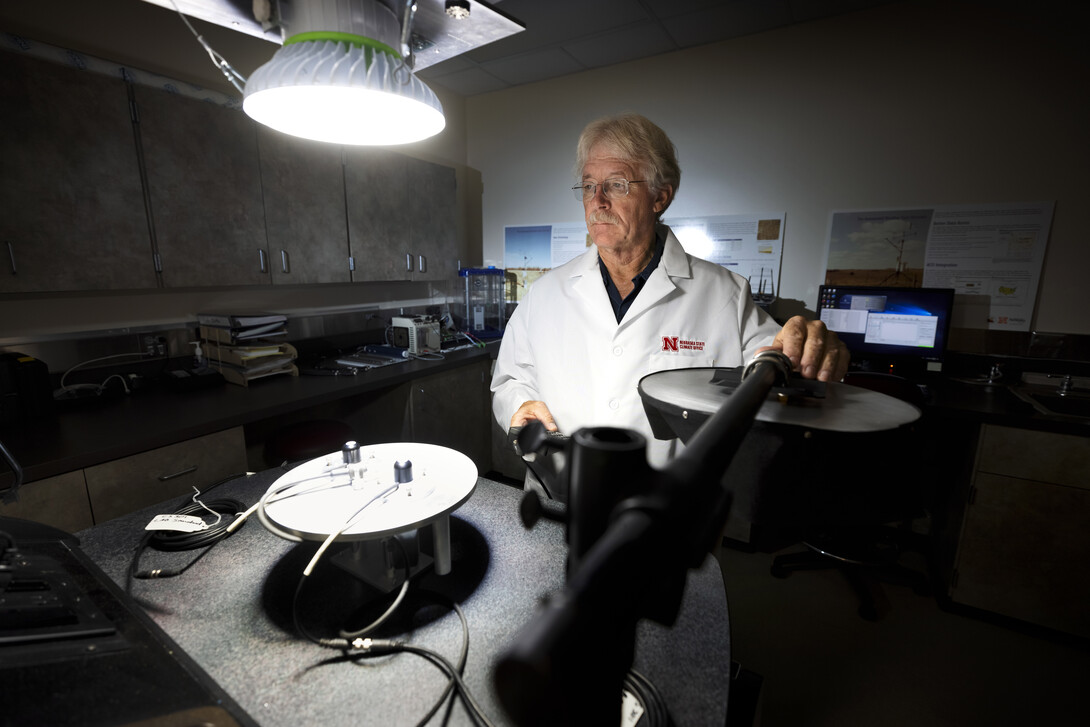 Glen Roebke, senior mesonet technician, runs tests on a set of solar radiation sensors for weather stations.