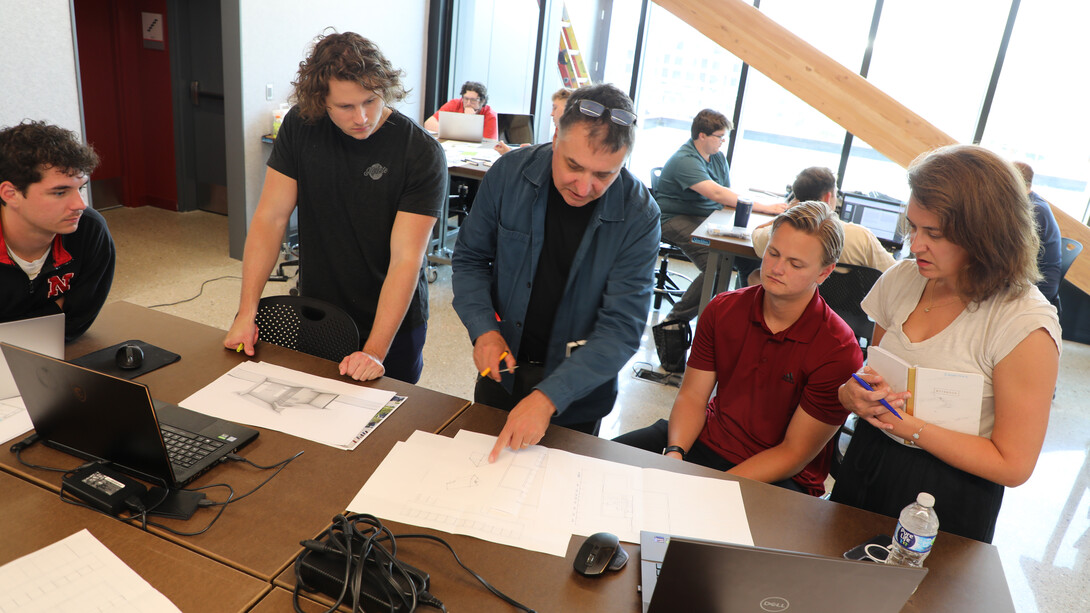 Jeffrey L. Day (center), professor of architecture and landscape architecture, and Jessica Scheuerman (right), founder and executive director of Partners for Livable Omaha, work with architecture master’s students Luke Heidenreich (left), Trent Weatherwax (second from left) and Alex Martino (second from right) on project concepts during a fall afternoon studio. (Kerry McCullough-Vondrak/College of Architecture)