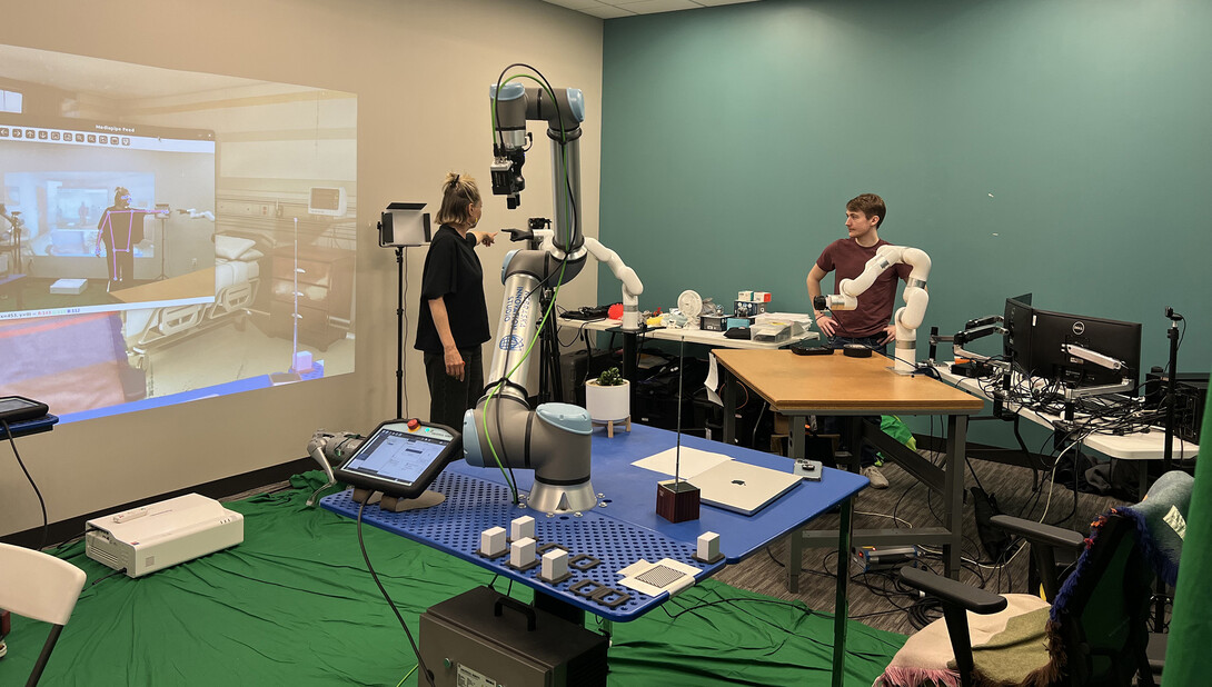 Ash Eliza Smith (left) works with Reid Brockmeier to control a robotic arm.