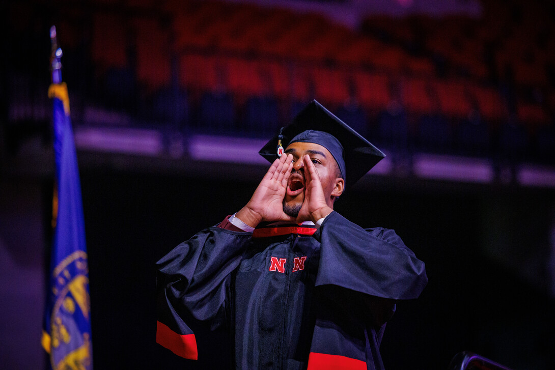 Graduate Jordan Ambrose yells back to family members during the graduate and professional degree ceremony May 16 at Pinnacle Bank Arena.