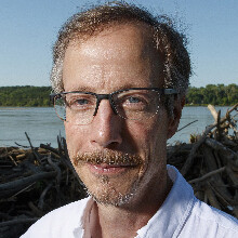 Craig Allen, a professor in the School of Natural Resources, poses next to a river.