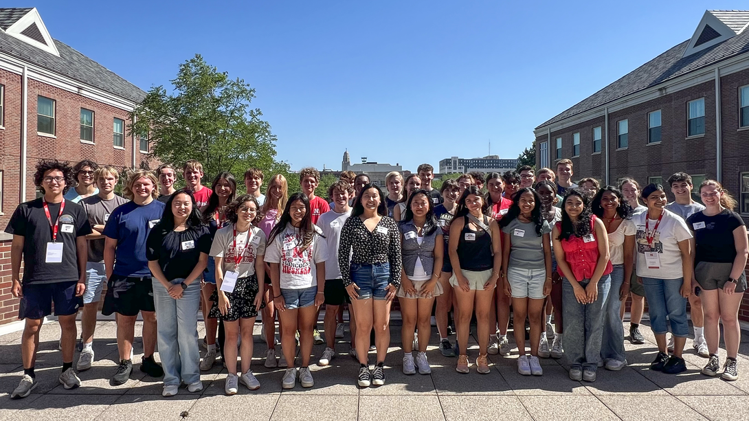 Thirty-nine college students — all members of the Jeffrey S. Raikes School of Computer Science and Management — pose for a photograph on the rooftop of the Kauffman Academic Residential Center on a clear day.