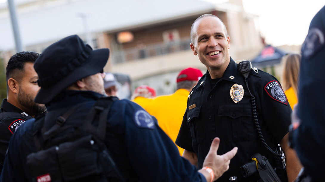 UNL Police Capt. John Backer chats with fellow police officers outside Memorial Stadium.
