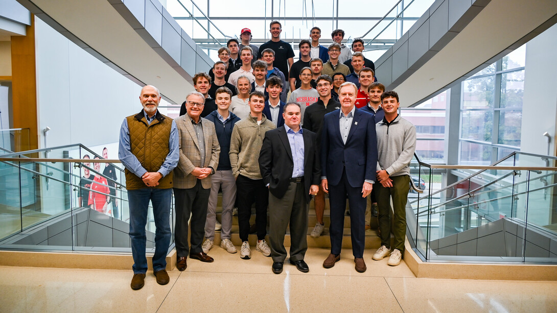 A group of 30 people — mostly University of Nebraska–Lincoln students in the Investors With Purpose program — pose for a photo on a staircase in Howard L. Hawks Hall.