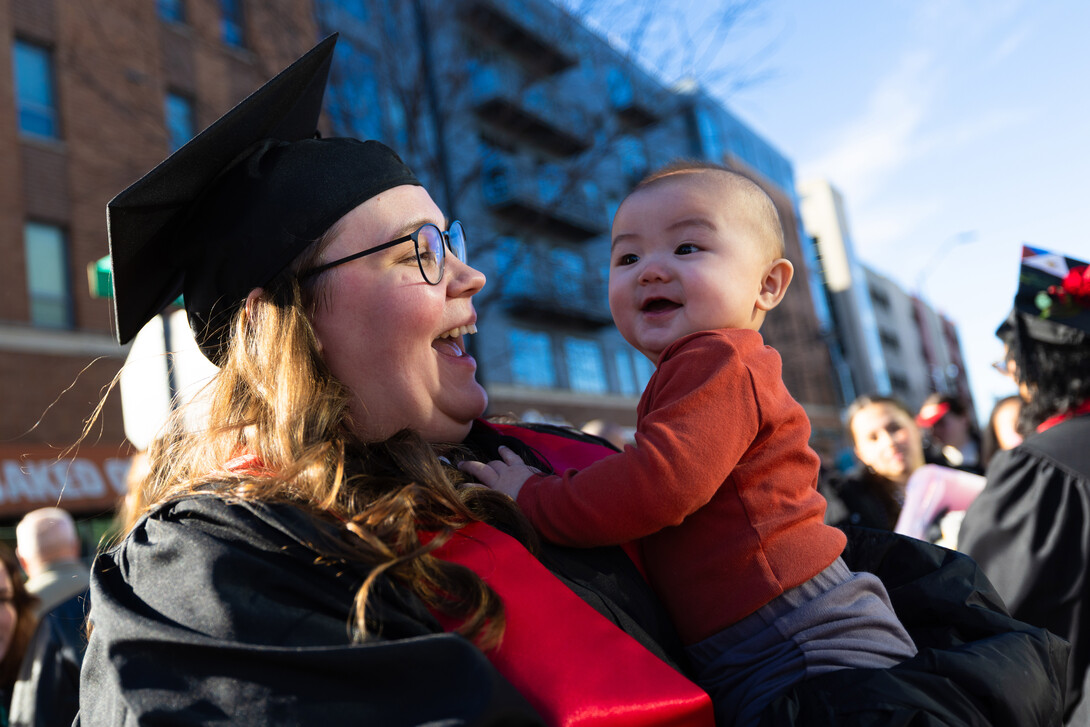 Casandra Naoe holds her infant son, Yukino, after leaving the undergraduate commencement ceremony. She earnedaving the undergraduate commencement ceremony Dec. 20 at Pinnacle Bank Arena.