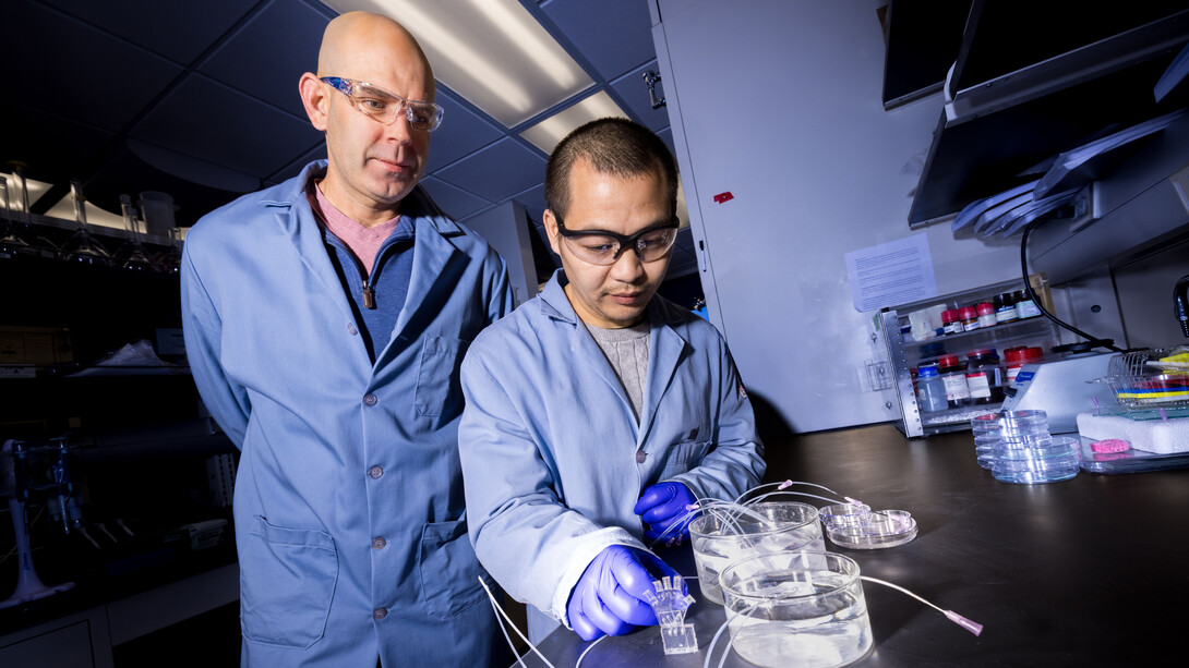 Stephen Morin (left), associate professor of chemistry, and Nengiian Huang, a graduate student in chemistry, pose for a photograph in a lab.