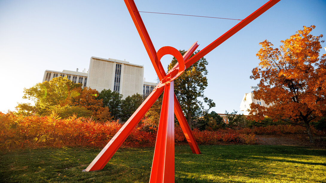 A close-up of "Old Glory" — a giant sculpture with red steel beams — on a fall day.