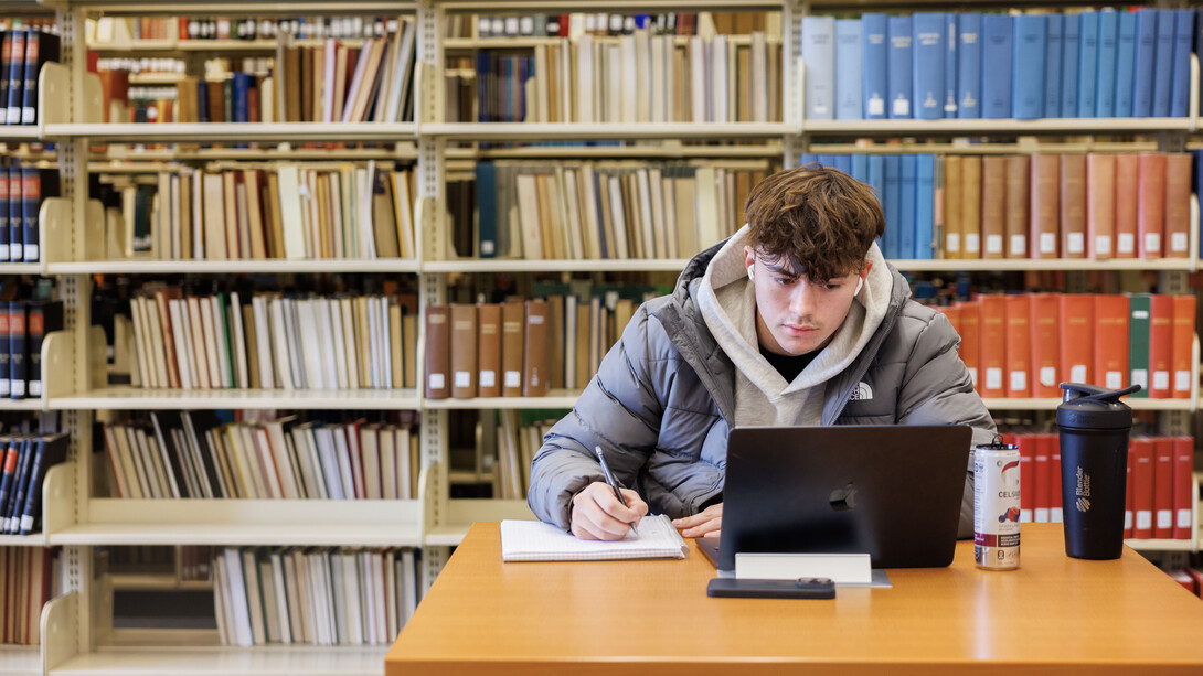 Kyler Elliott, a nutrition and health sciences major, studies at a desk in Love Library.