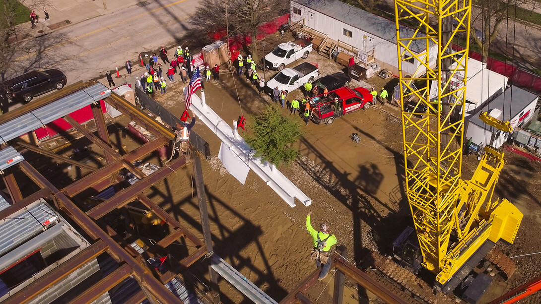A crane lifts the final beam into the air as Hausmann Construction workers ready to bolt it into place. The new College of Education and Human Sciences building is replacing Mabel Lee Hall on 14th Street, between Vine and W streets.