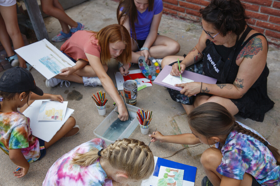 A counselor helps art students