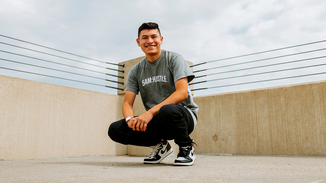 Edwin Mendez-Rodriguez crouches on the top level of a parking garage in Lincoln.