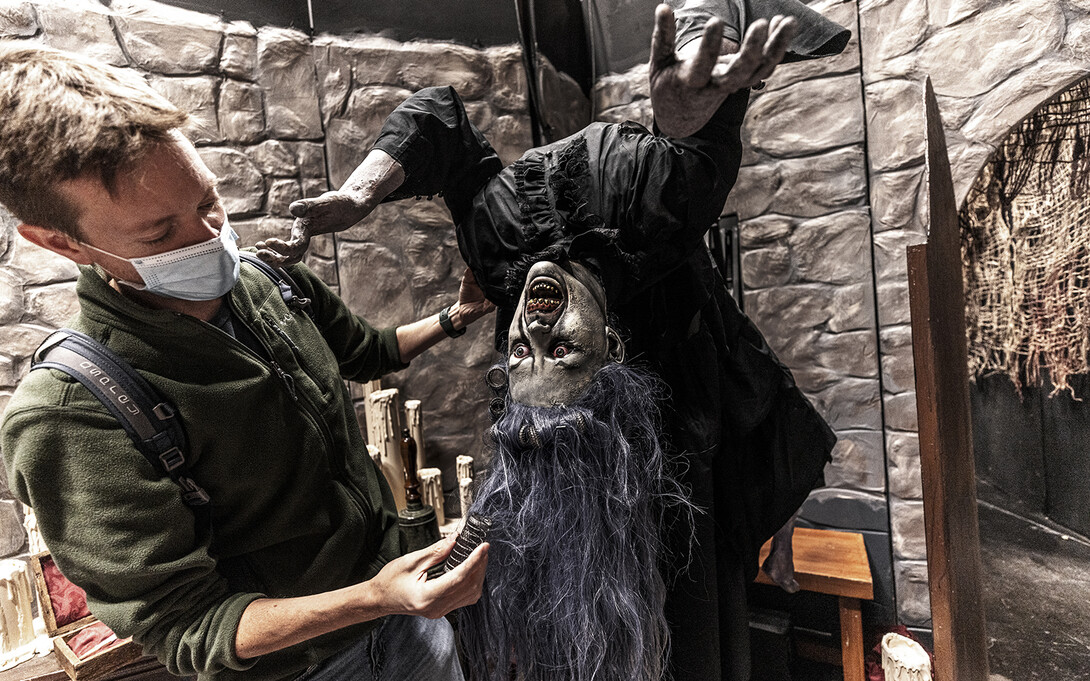 Andy Park, creative director with the Nebraska Repertory Theatre, adjusts the hair on one of the animated ghouls in “ShakesFear.” The production has turned Howell Theatre’s stage and backstage into a haunted house with a Shakespeare twist.