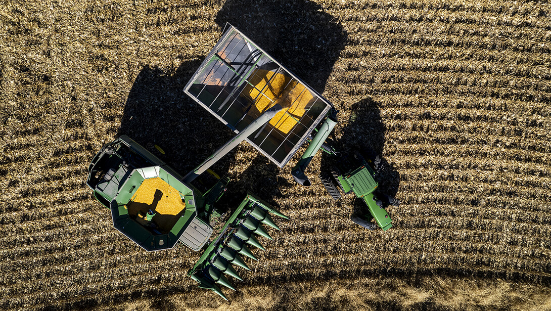 An aerial photograph shows a combine transferring grain to a tractor wagon during a harvest of corn in Lancaster County, Nebraska. 