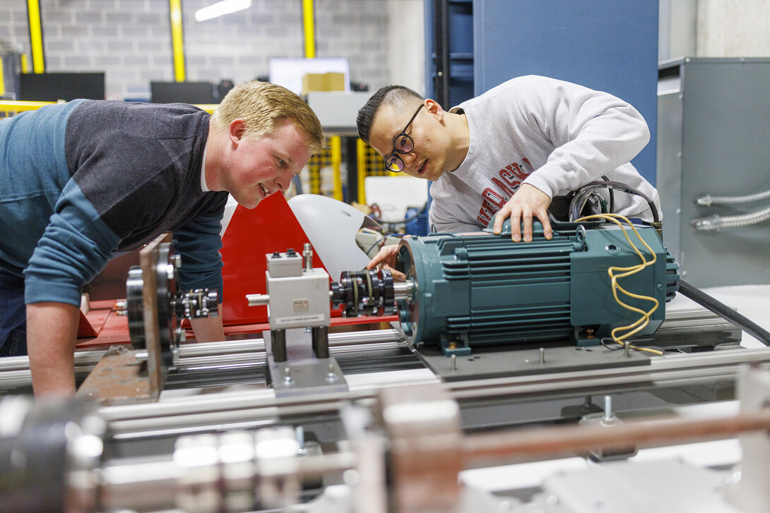 Jun Wang, on right, explains power trains in an electrical engineering lab. 