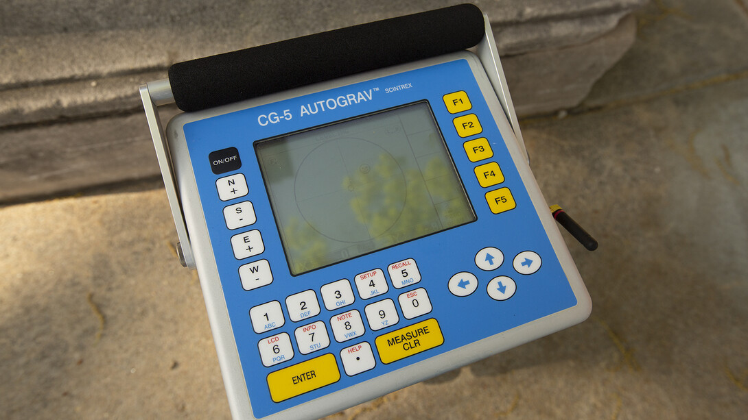 A gravimeter sits ready for calibration on the gravity base station Kris Guthrie established at the base of the Morrill Hall steps.