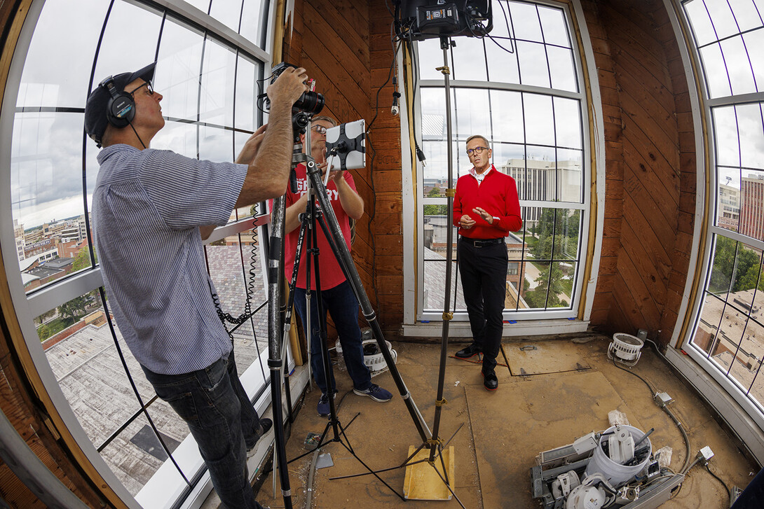 Dave Fitzgibbon (from left) and Curt Bright record a welcome back message from Chancellor Ronnie Green inside the Love Library cupola on Aug. 16.