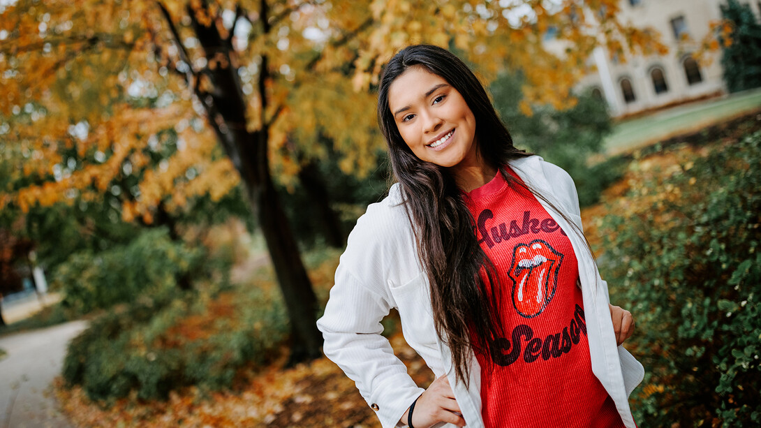 Mayah Delgado-Walker stands on East Campus in front of a tree with yellow leaves.