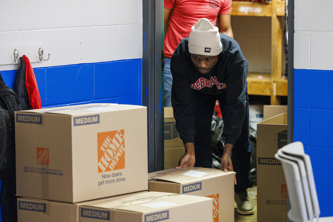 Emmanual Audu, a masters student, slides out a filled box from a Malone Center storage closet. The center is moving out in the next few weeks to temporary locations while a new center is built on the site.