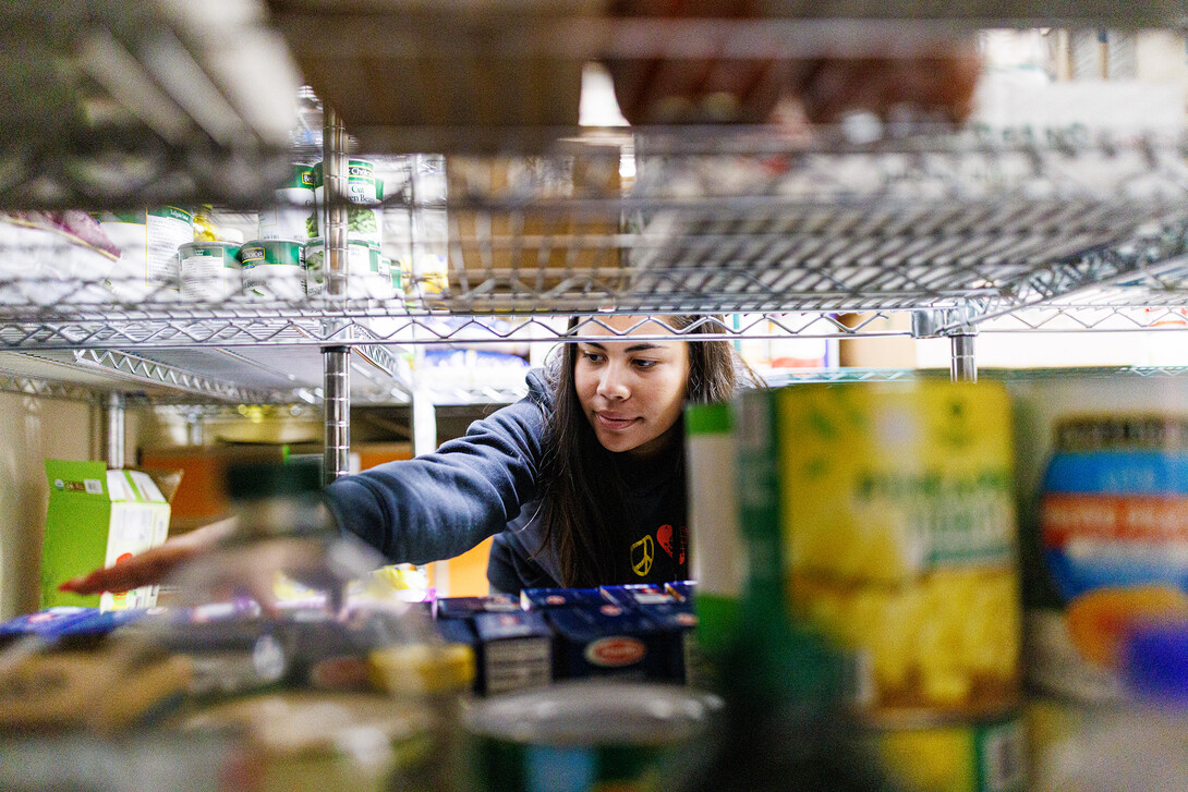 Bree Bell, a freshman from Omaha, sorts food in the store room at Matt Talbot