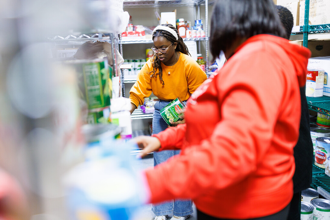 Maryam Sule,a freshman chemical engineering student from Bellevue, sorts food in the store room at Matt Talbot