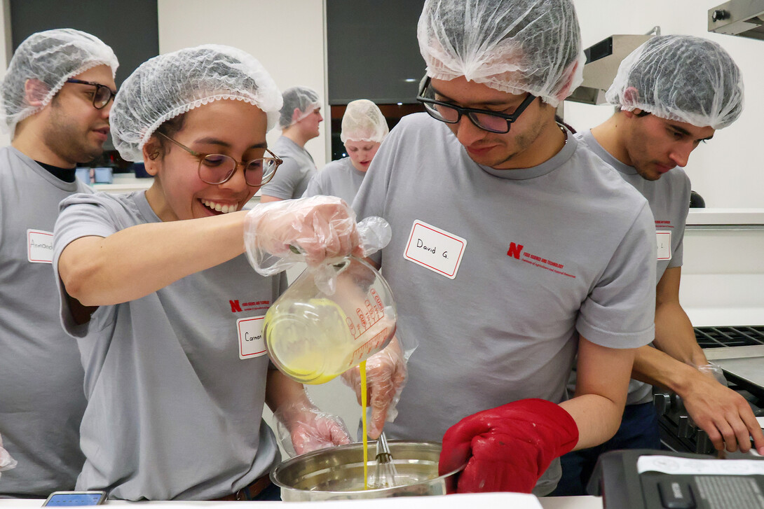 Carmen Perez-Donado pours egg into a mixture as David Fabian Gomez Quintero stirs during the Battle of the Food Scientists Feb. 15 at the Food Innovation Center.