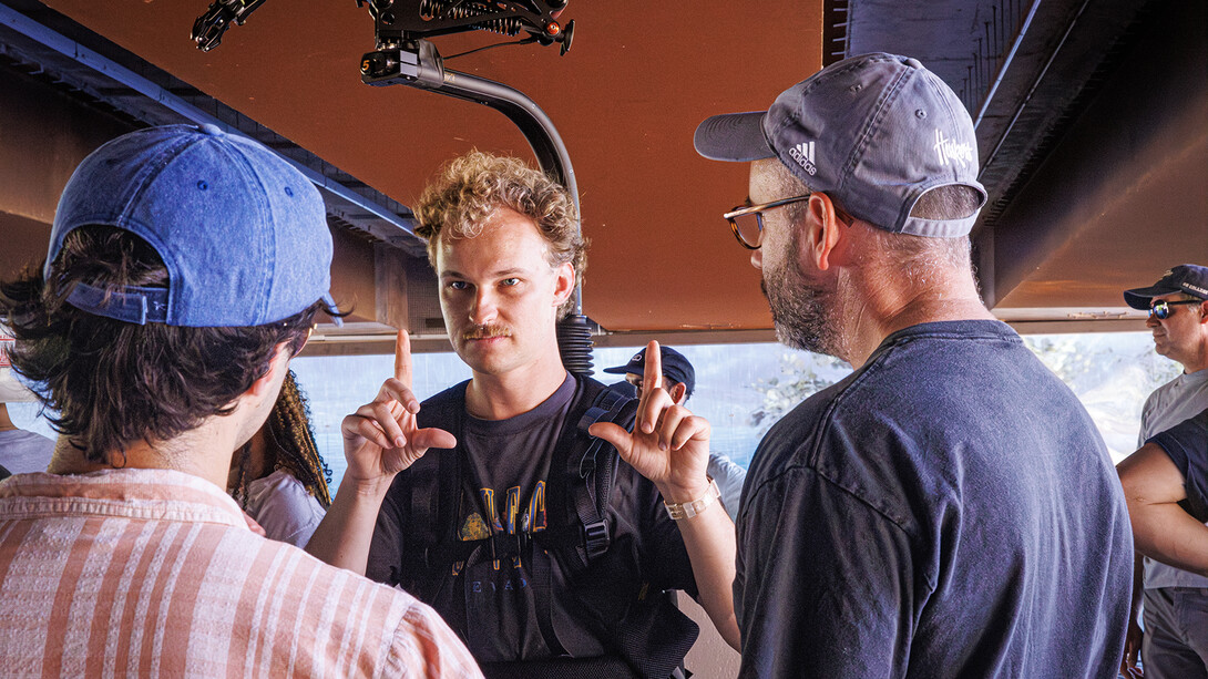 Carter Knopik (center) talks with (from left) Matthew Strasburger and Aaron Nix during filming of UNL's national institutional spot.