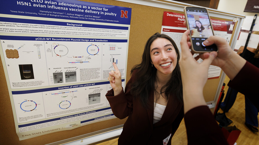 Hamelynn Harzman of Iowa State University poses for a photo taken by her poster session neighbor Adrian Dunivan of the Universitiy of Missouri during the Nebraska Summer Research Symposium on Aug. 6.